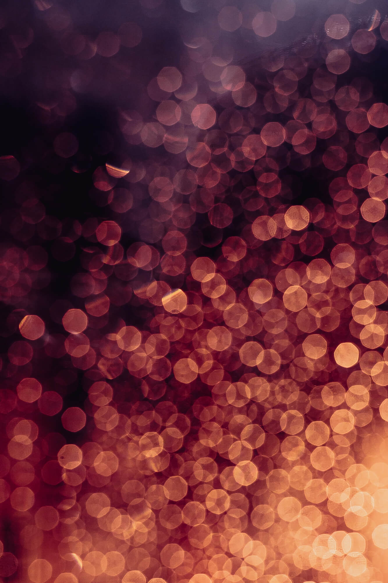 Abstraktes Bild aus runden Lichtreflexen (Bokeh) in warmen Orange- und Rottönen. Stimmungsvolles Hintergrundbild.