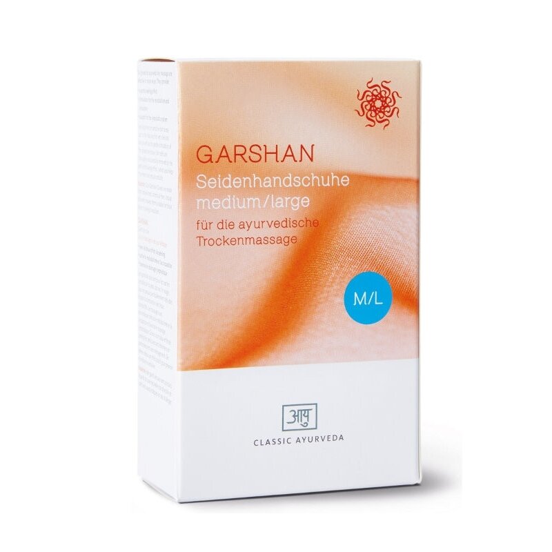 Ein Nahaufnahme-Foto der Verpackung von Garshan-Seidenhandschuhen. Die Box ist in den Farben Weiß und einem warmen Orange-Gelb gehalten. Der Text „GARSHAN Seidenhandschuhe medium/large für die ayurvedische Trockenmassage" ist darauf zu sehen. Unten auf der Box steht „आयु CLASSIC AYURVEDA".